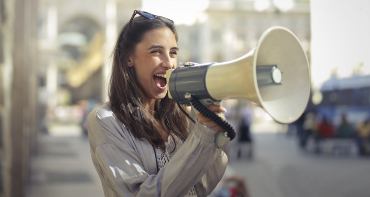 girl holding a megaphone, to denote welcoming a new client during the client onboarding process